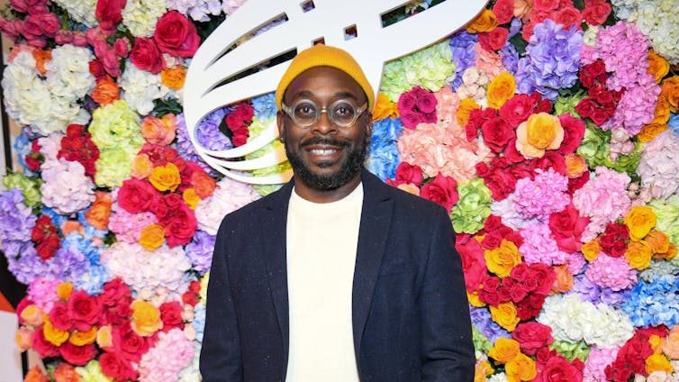 James Ijames in front of floral backdrop.