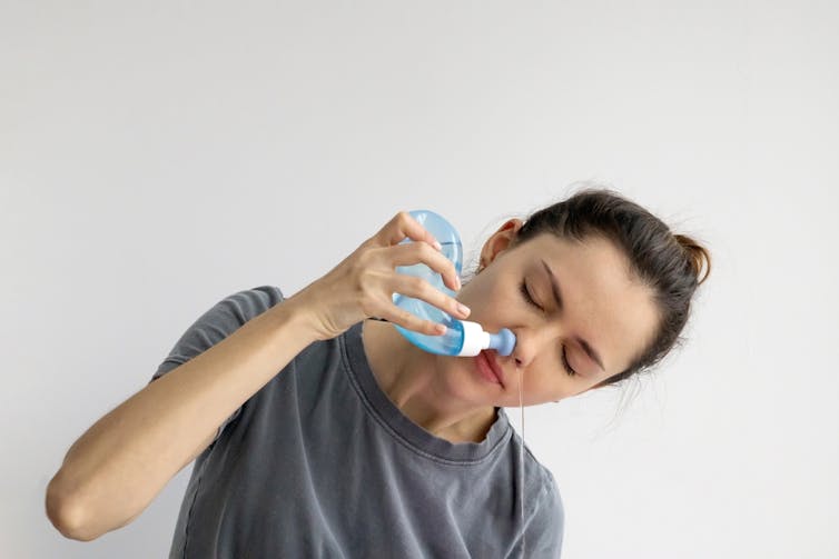 A woman doing a nasal rinse.