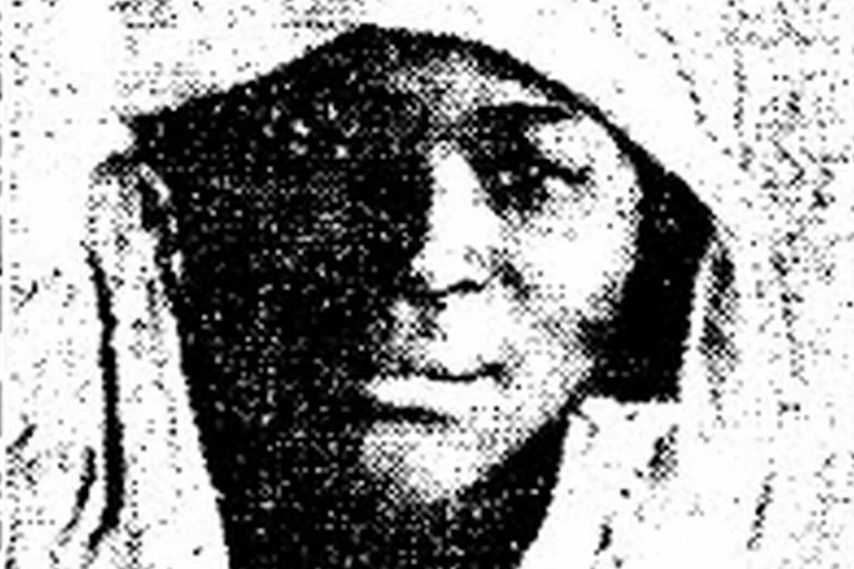 A black-and-white photo depicts the face of a Black woman wearing a head covering.