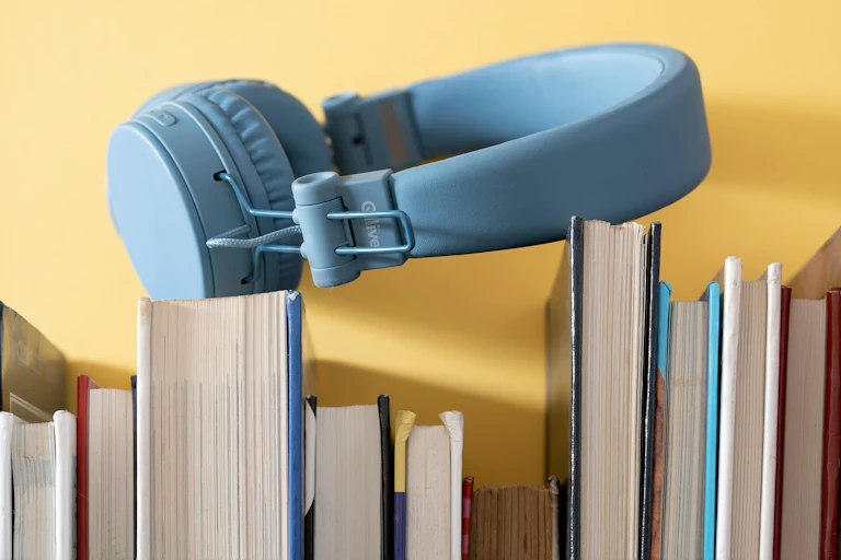 blue headphones on a shelf of books, spine out