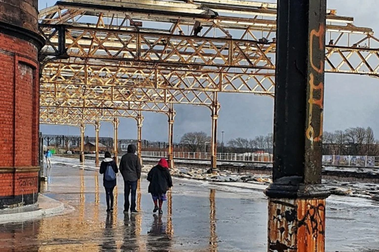 Three people walking in an industrial area.