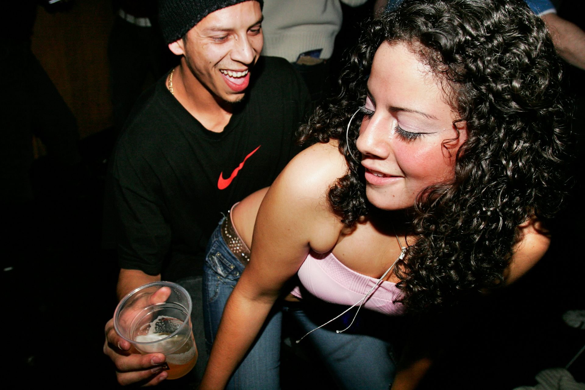 A man and a woman dance with each other. Both are smiling. 