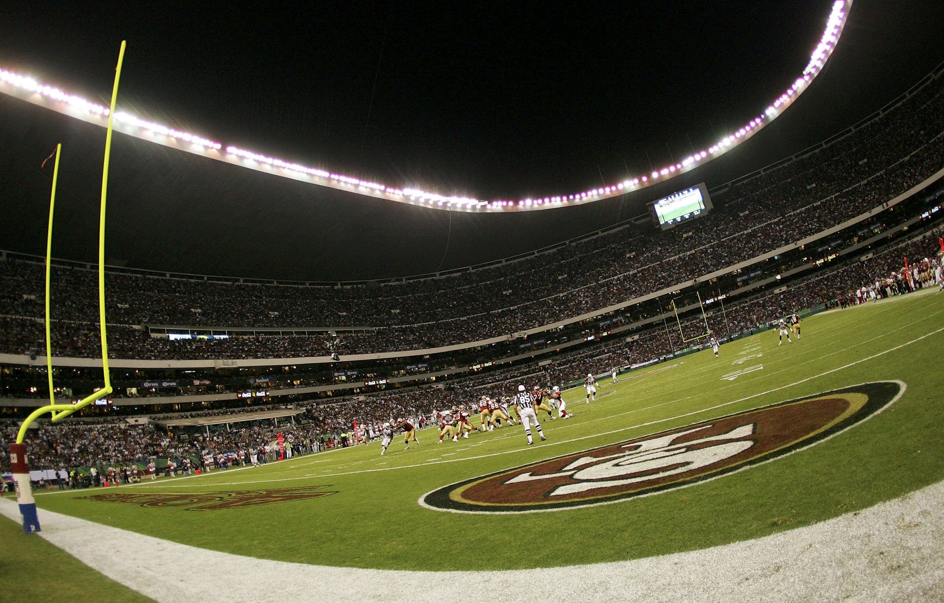 A laerge stadium is seen with American football posts in the foreground