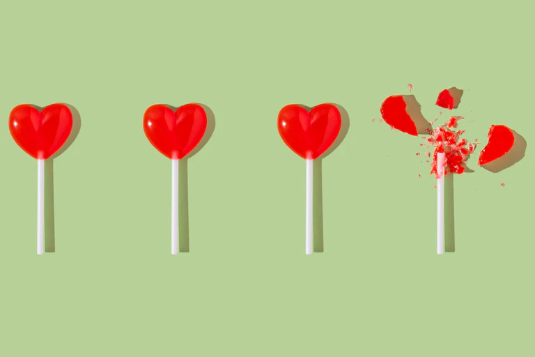 Four heart-shaped lollipops; one is broken.