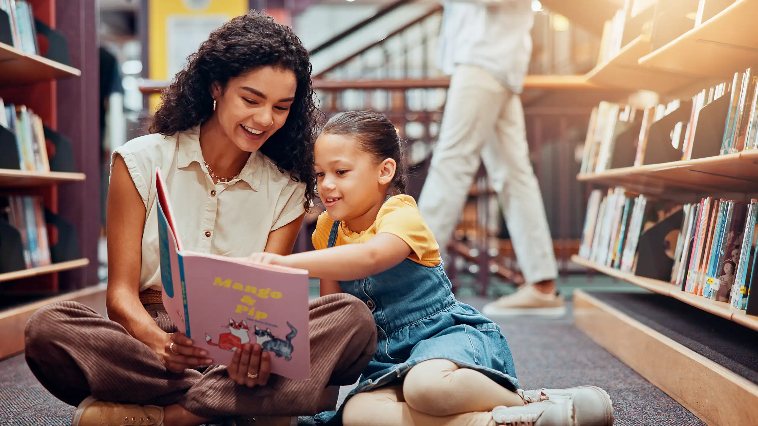 Woman and child looking at book in library
