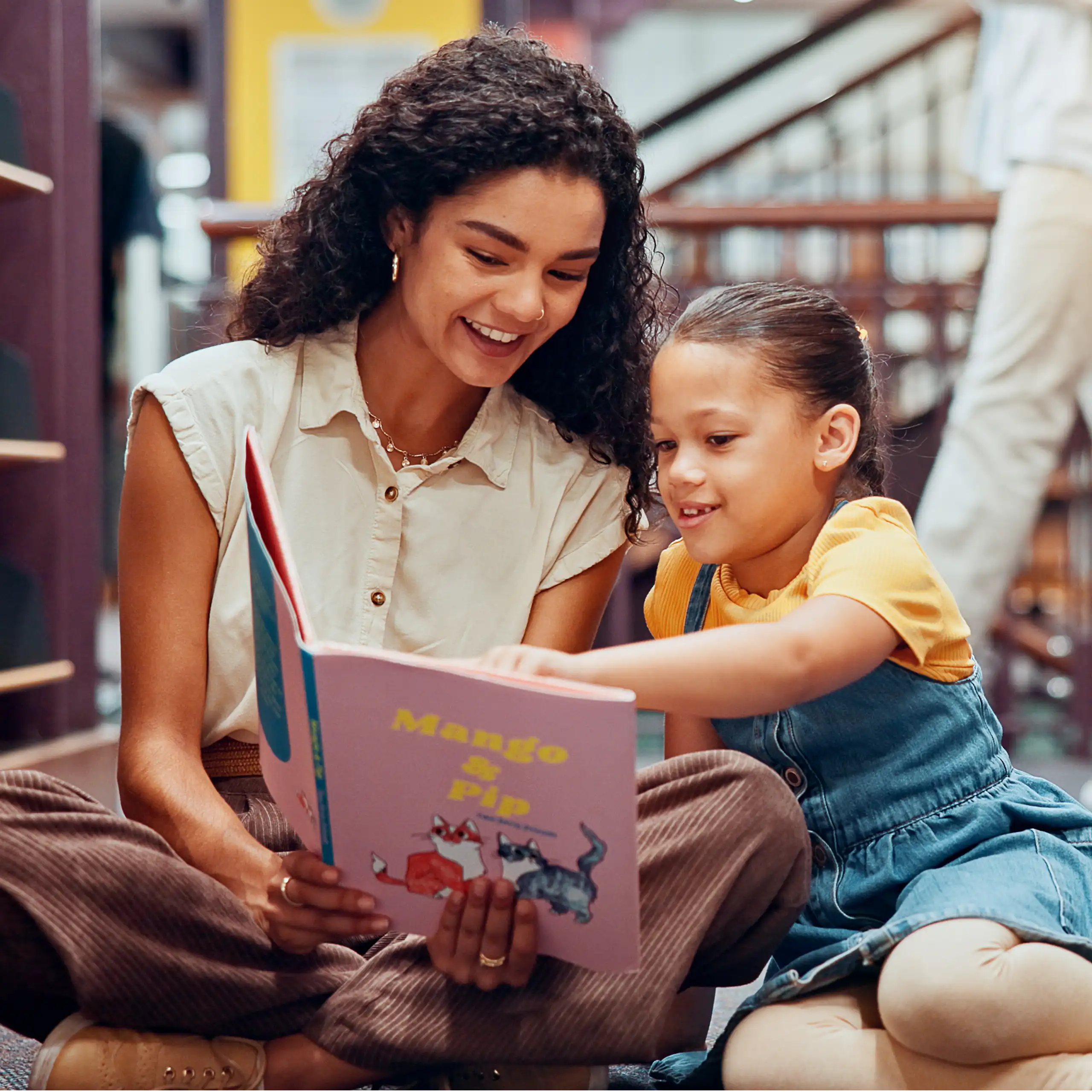 Woman and child looking at book in library