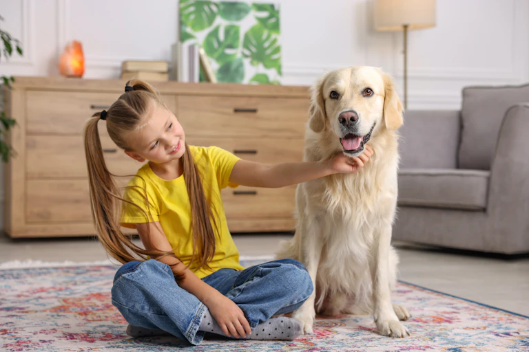 Una niña acaricia el mentón de un perro