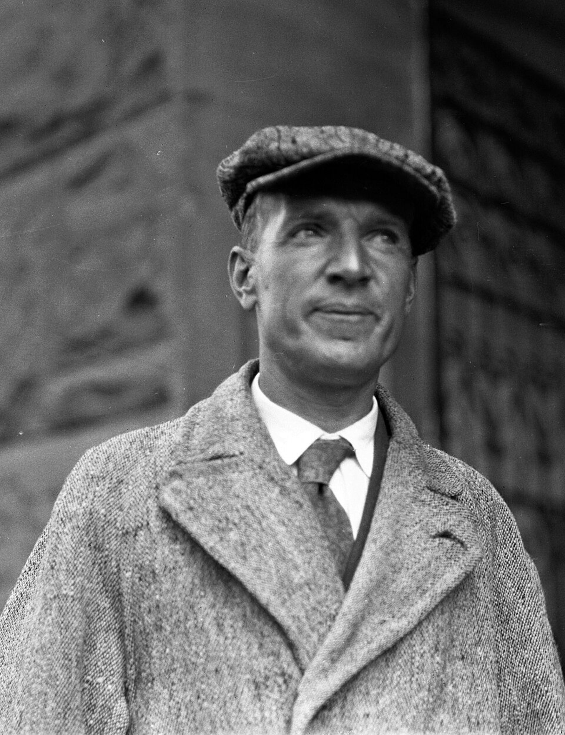 Un hombre con abrigo, camisa blanca y corbata.