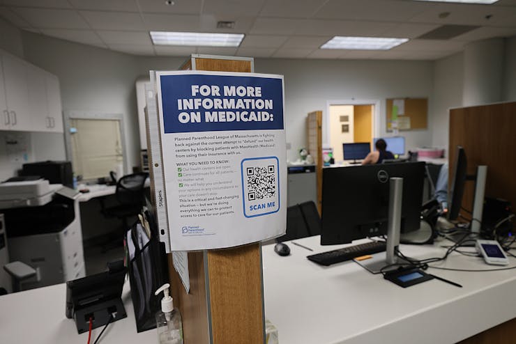 A sign for more information about Medicaid is seen in a clinic's office.