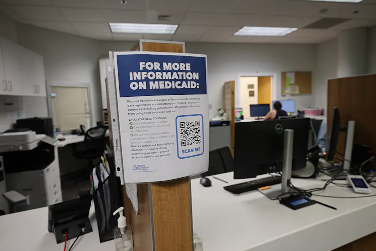 A sign for more information about Medicaid is seen in a clinic's office.