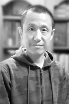 A smiling man in a hoodie