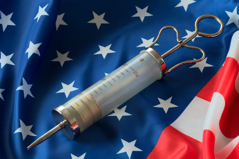 an antique syringe sits on a United States flag