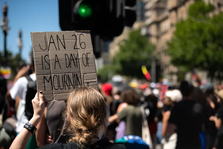 A protest sign that says Jan 26 is a day of mourning