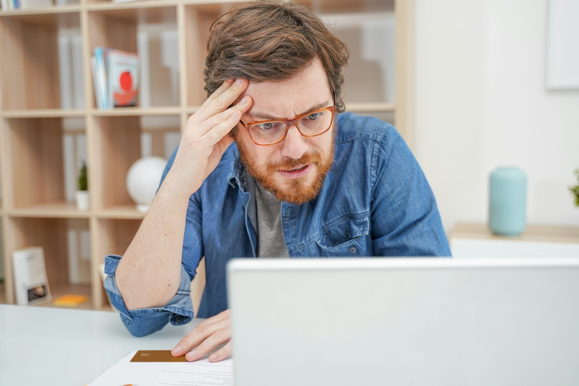 Un home mira un ordinador amb cara de molta preocupació.