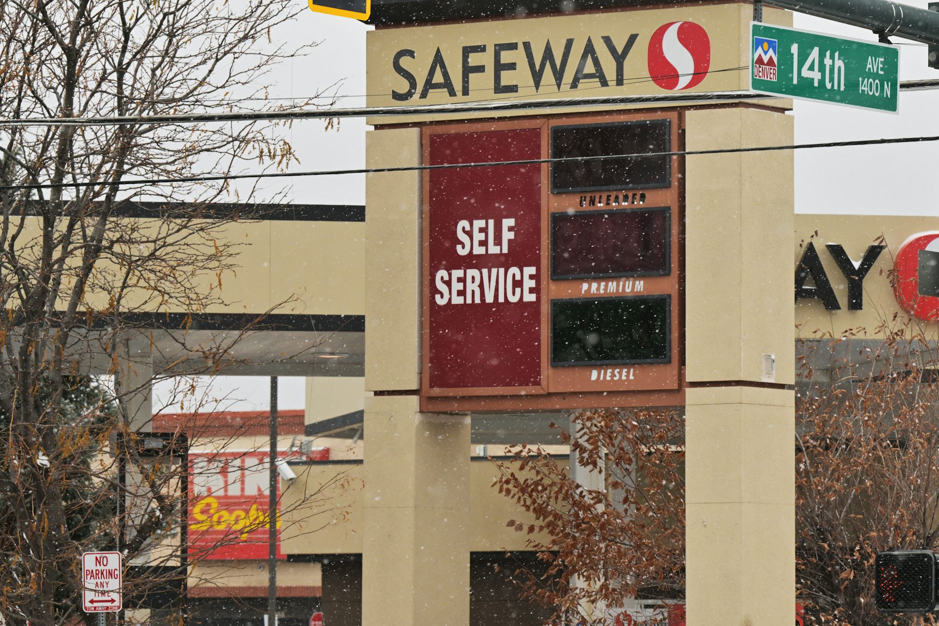 A Safeway gas station sign is in foreground and in the background a King Soopers storefront sign is visible.