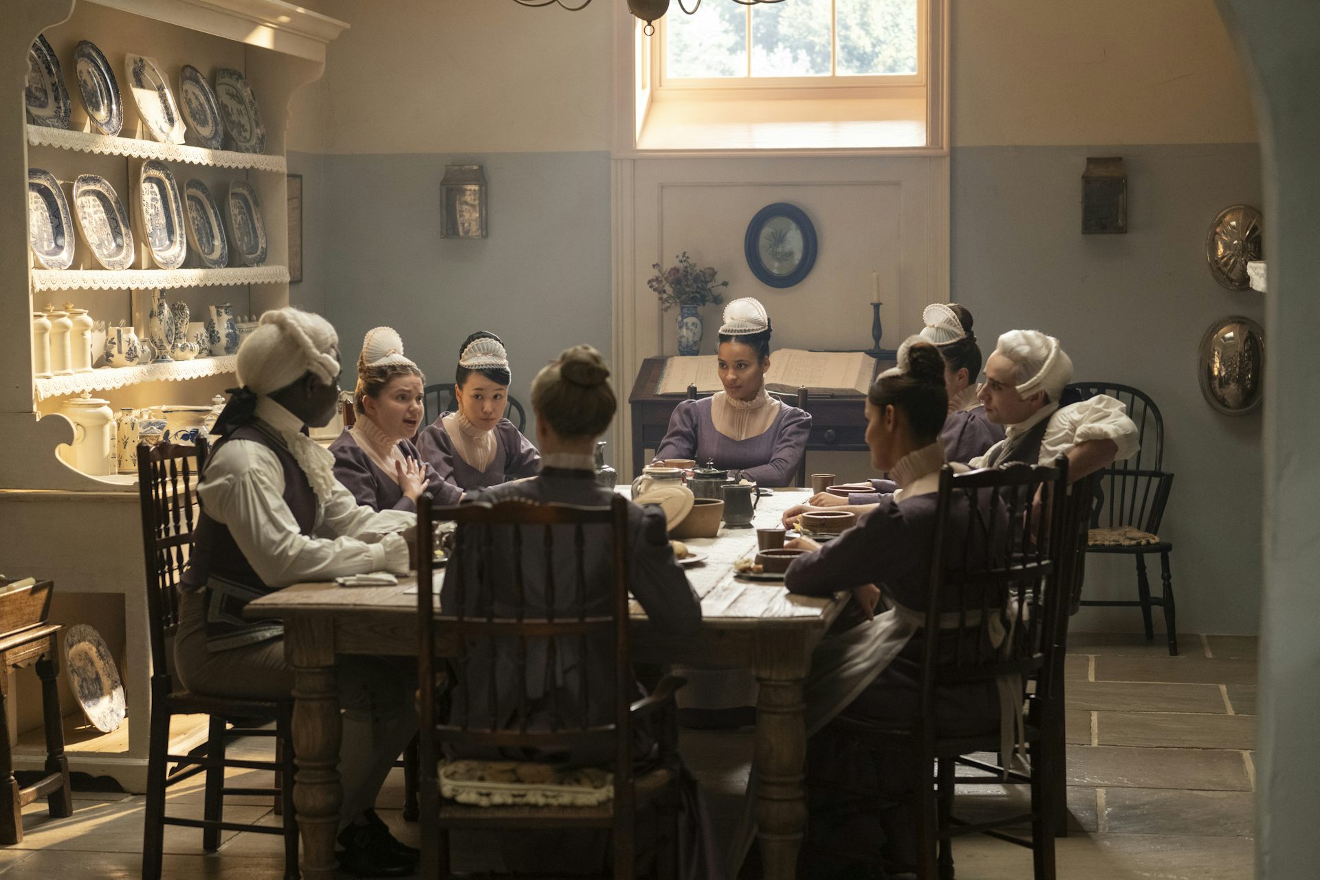 The Bridgerton servants sharing a meal below stairs.