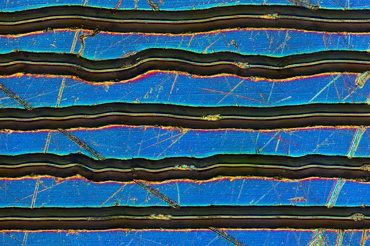 Partes del surco de un disco de vinilo vistas con un microscopio.