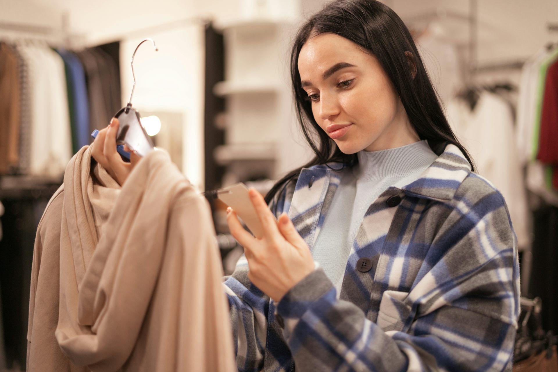una joven mira la etiqueta de una prenda.