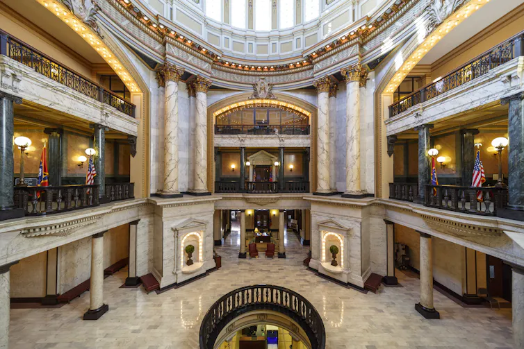 A large, multifloor public space with gilded arches and polished floors.