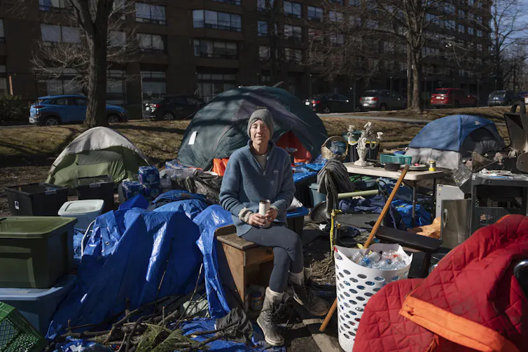 Una mujer sentada en una silla en un campamento para alborotadores.