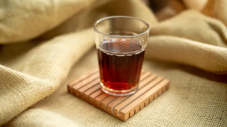 A cup of tea sits on a coaster.