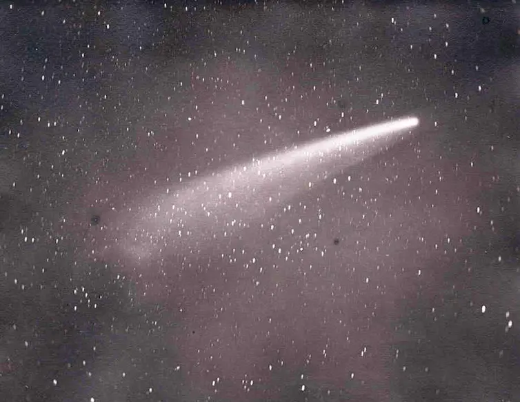 A white streak in a purplish starry sky.