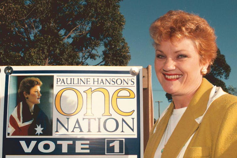 Pauline Hanson in the 90s next to a sign for her campaign.