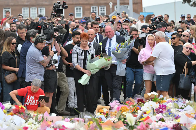 Pauline Hanson and Barnaby Joyce stand in the centre of a large crowd to lay flowers
