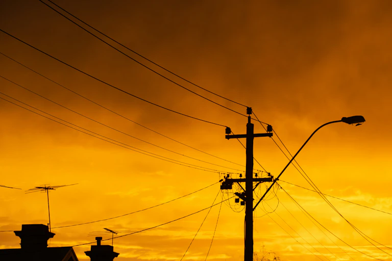 Power lines silhouetted against a sunset