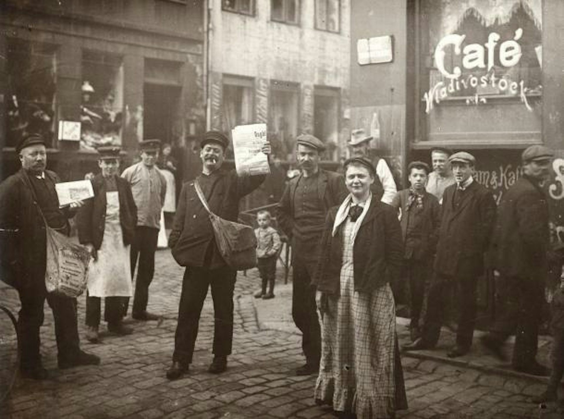 Black and white photo of people standing on the street.