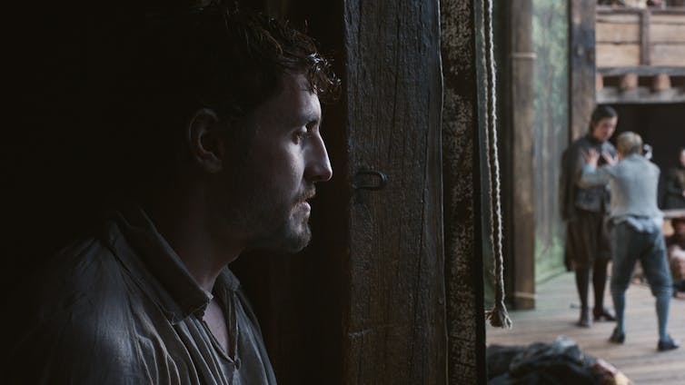 Un hombre observa una representación entre bambalinas.