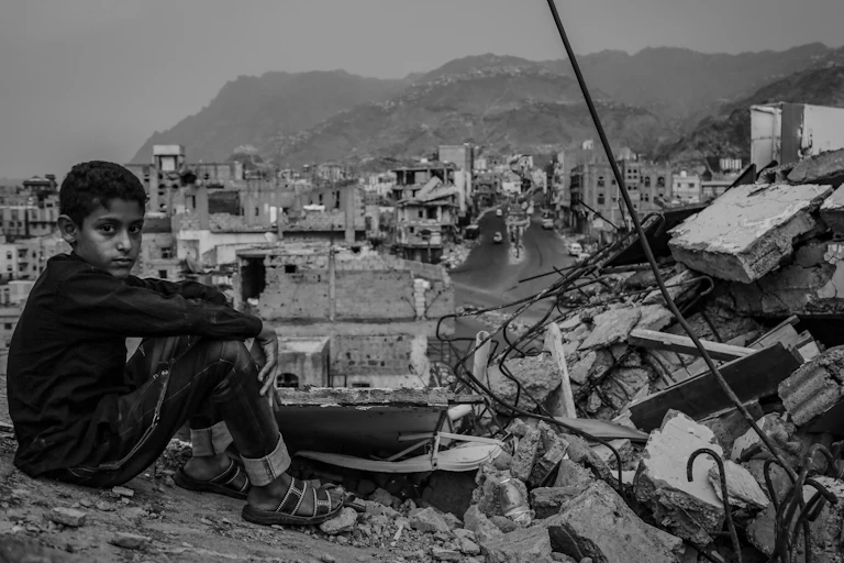 Taiz Yemen - 22 Aug 2016 : black and white image of a Yemeni child sitting on the rubble of a destroyed house in the city of Taiz, Yemen