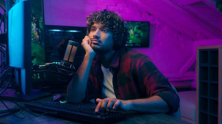 A young man on a computer in a dark room