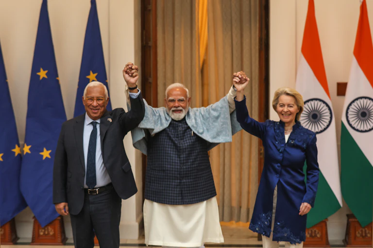 Ursula von der Leyen, Antonio Luis Santos da Costa and Narendra Modi hold hands and raise them in the air to mark the conclusion of the eu-india free trade agreement.