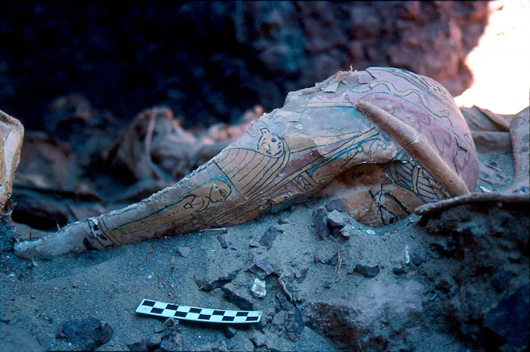 partial Egyptian funerary mask in dirt