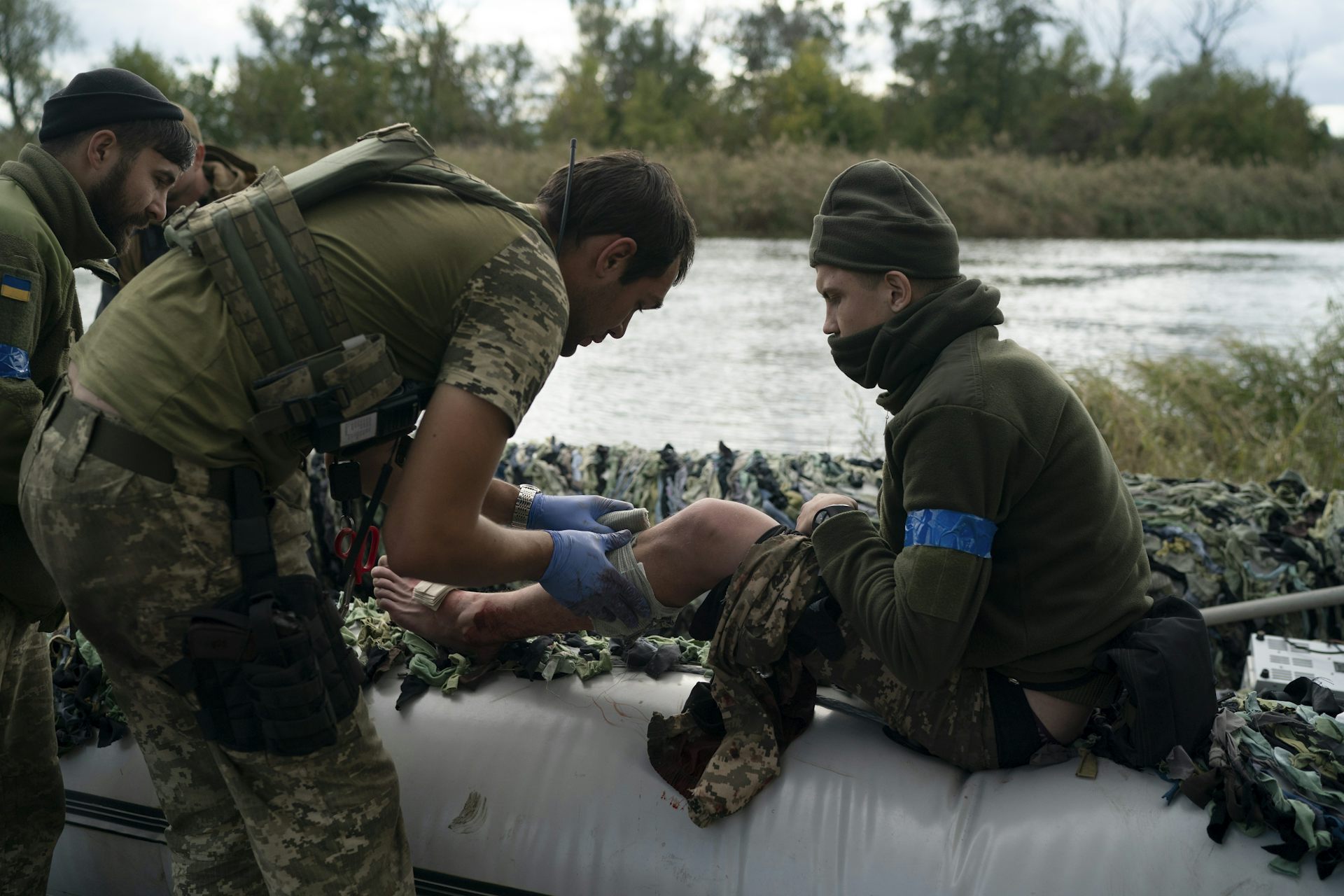 A Ukrainian medic treats a soldier for leg injuries.