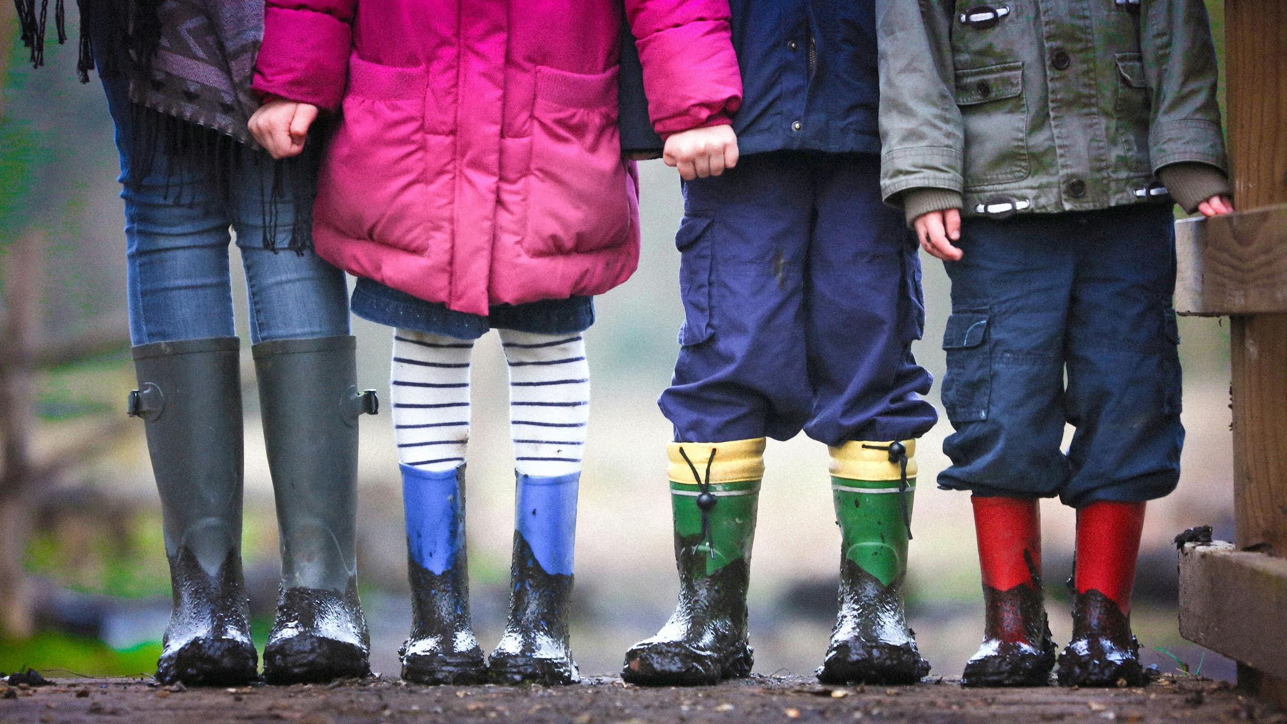Four children standing on dirt during daytime.