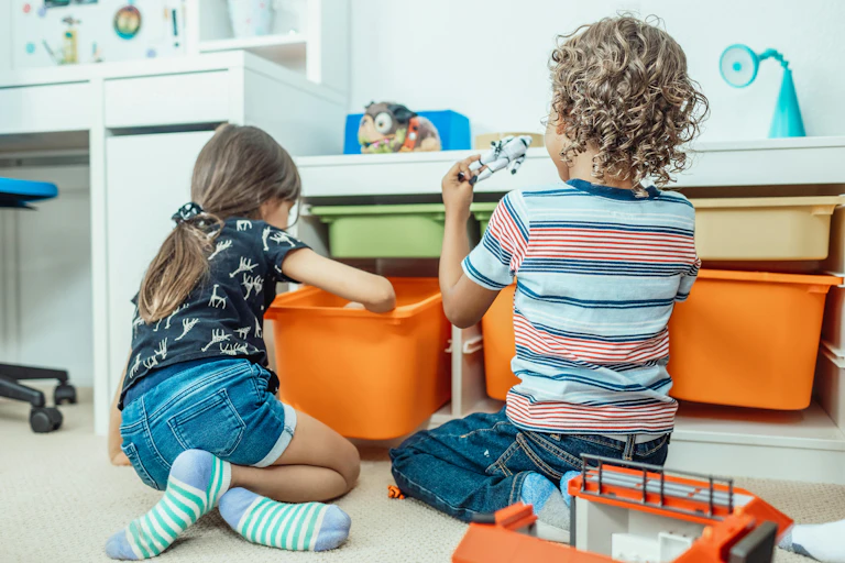 Two kids pull blocks out of drawers.