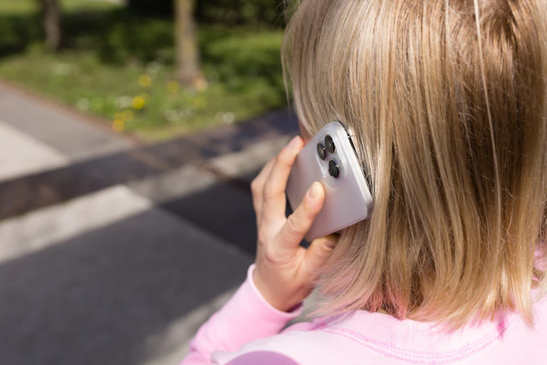 Una mujer vista por detrás escucha por su móvil.