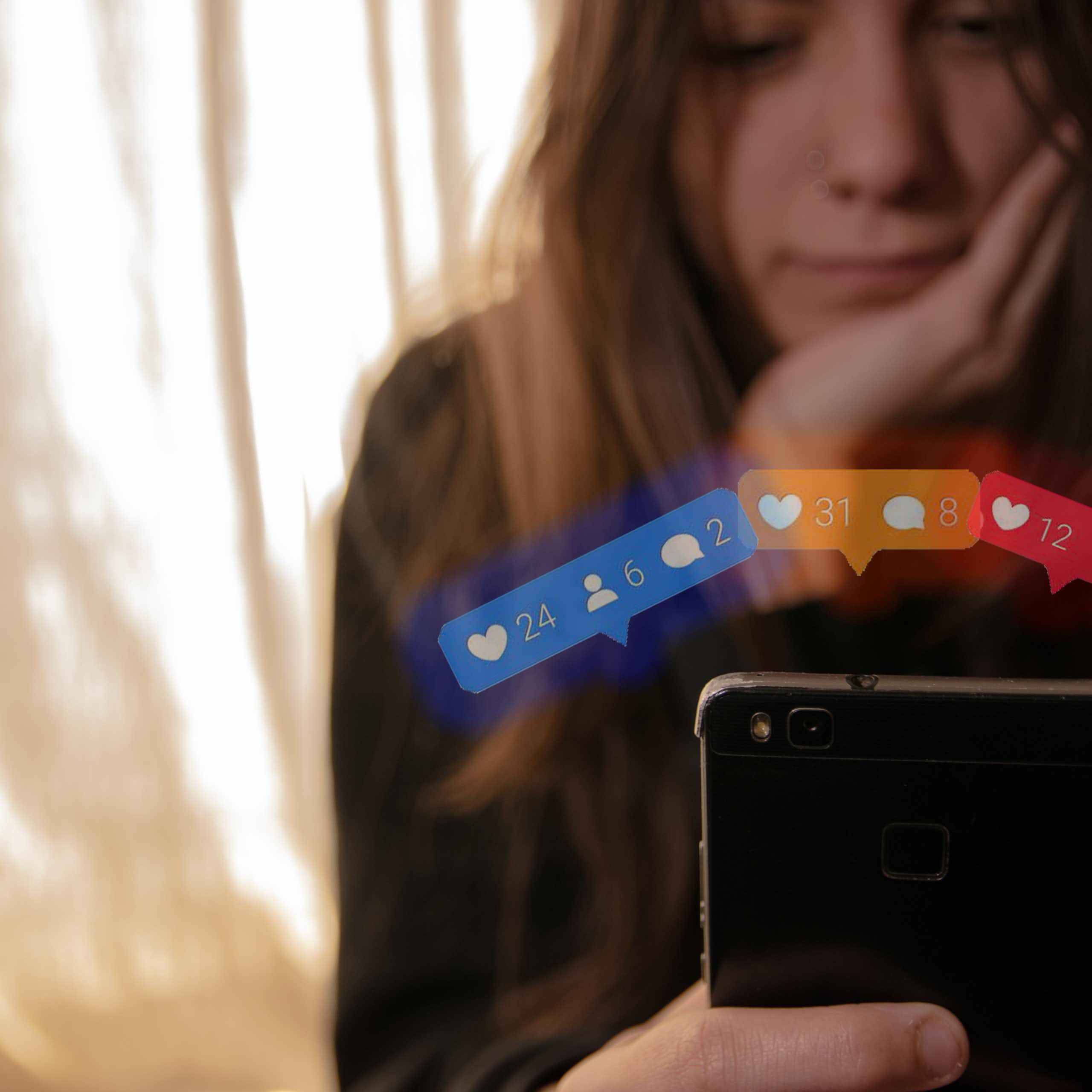 Una adolescent mira la pantalla d'un mòbil