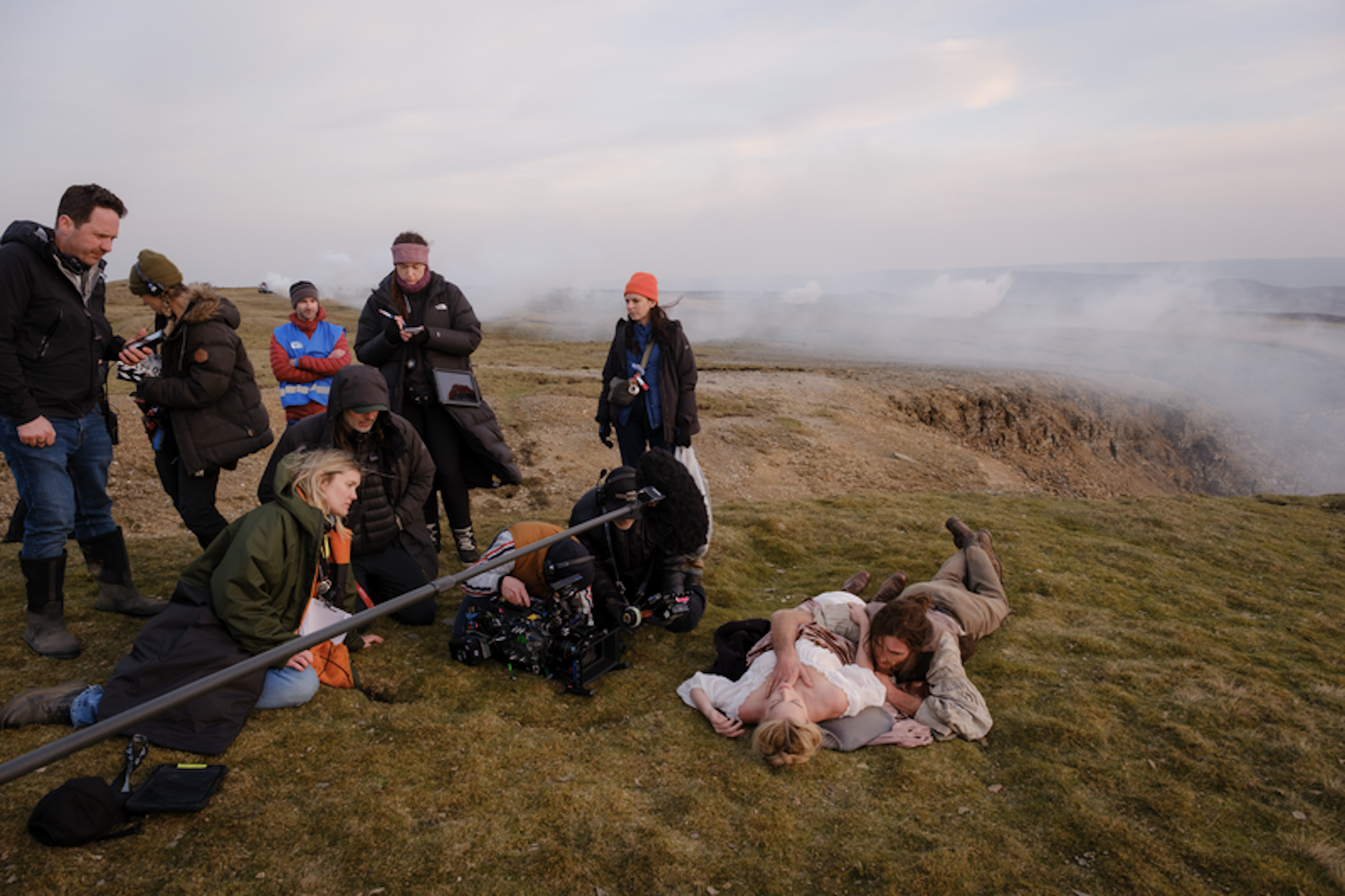 Jacob Elordi and Margot Robbie in an embrace on the ground outside, while being filmed for Wuthering Heights