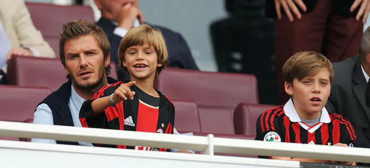 David Beckham watches a football game with his two young sons in 2010