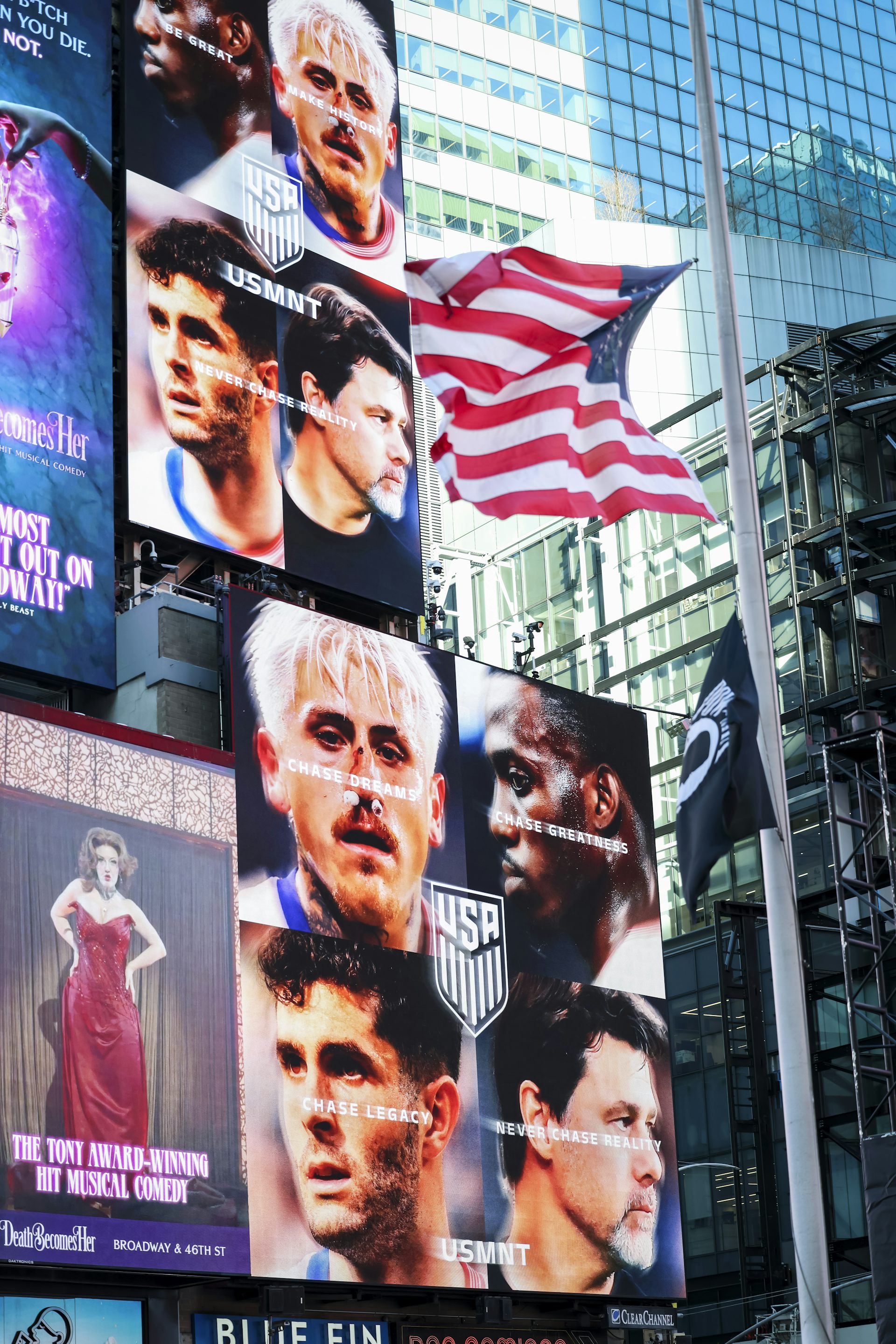 An American flag flies next to posters of sporting stars' faces.