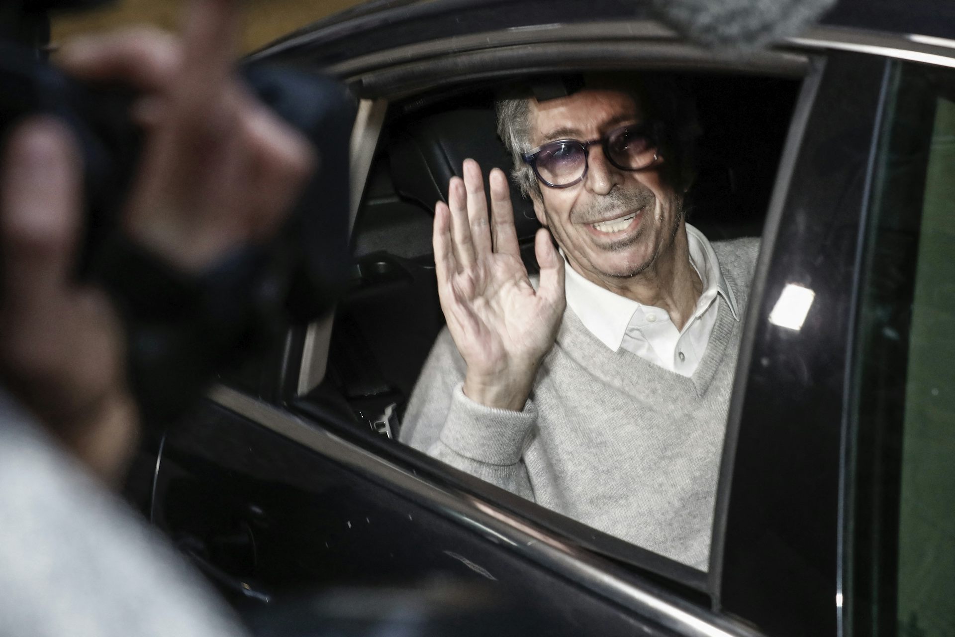L'ancien maire de Levallois-Perret Patrick Balkany salue depuis l'arrière d'une voiture après sa libération de la prison de la Santé, le 12 février 2020. 