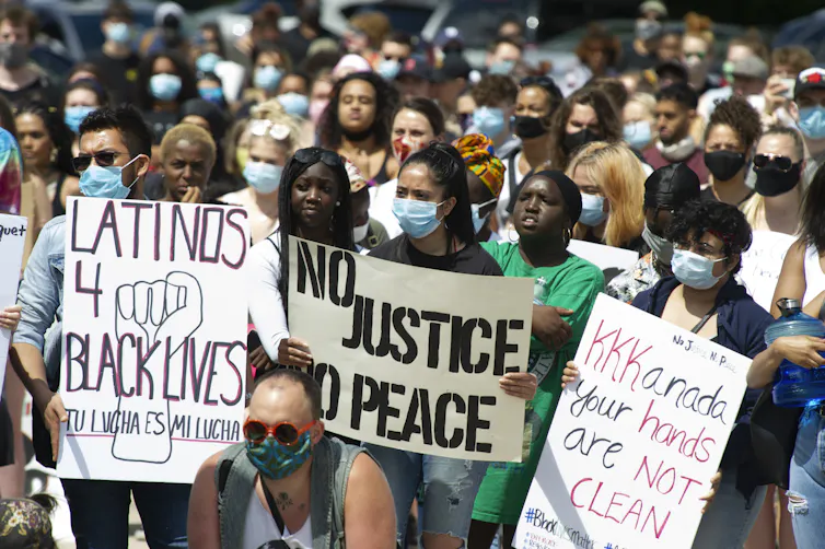 People seen protesting with signs such as 'no justice no peace' and 'KKKanada your hands aren't clean