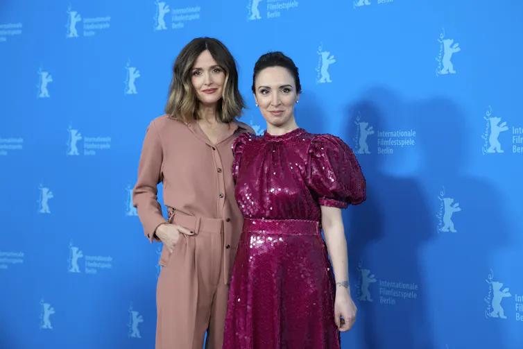 Dos mujeres de cabello oscuro están juntas y ríen.
