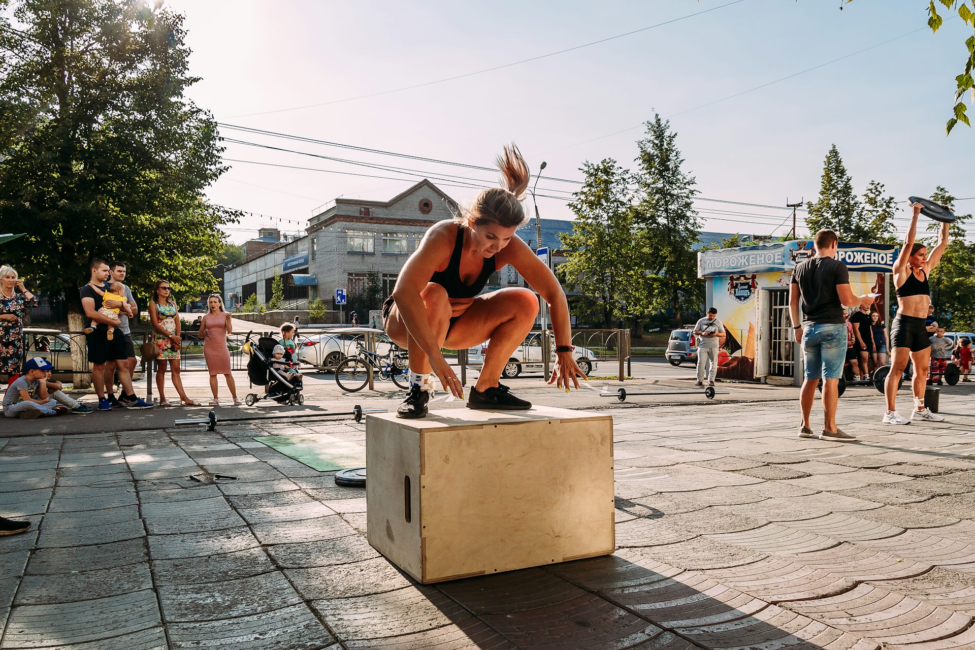 Una mujer salta sobre un cajón de madera.