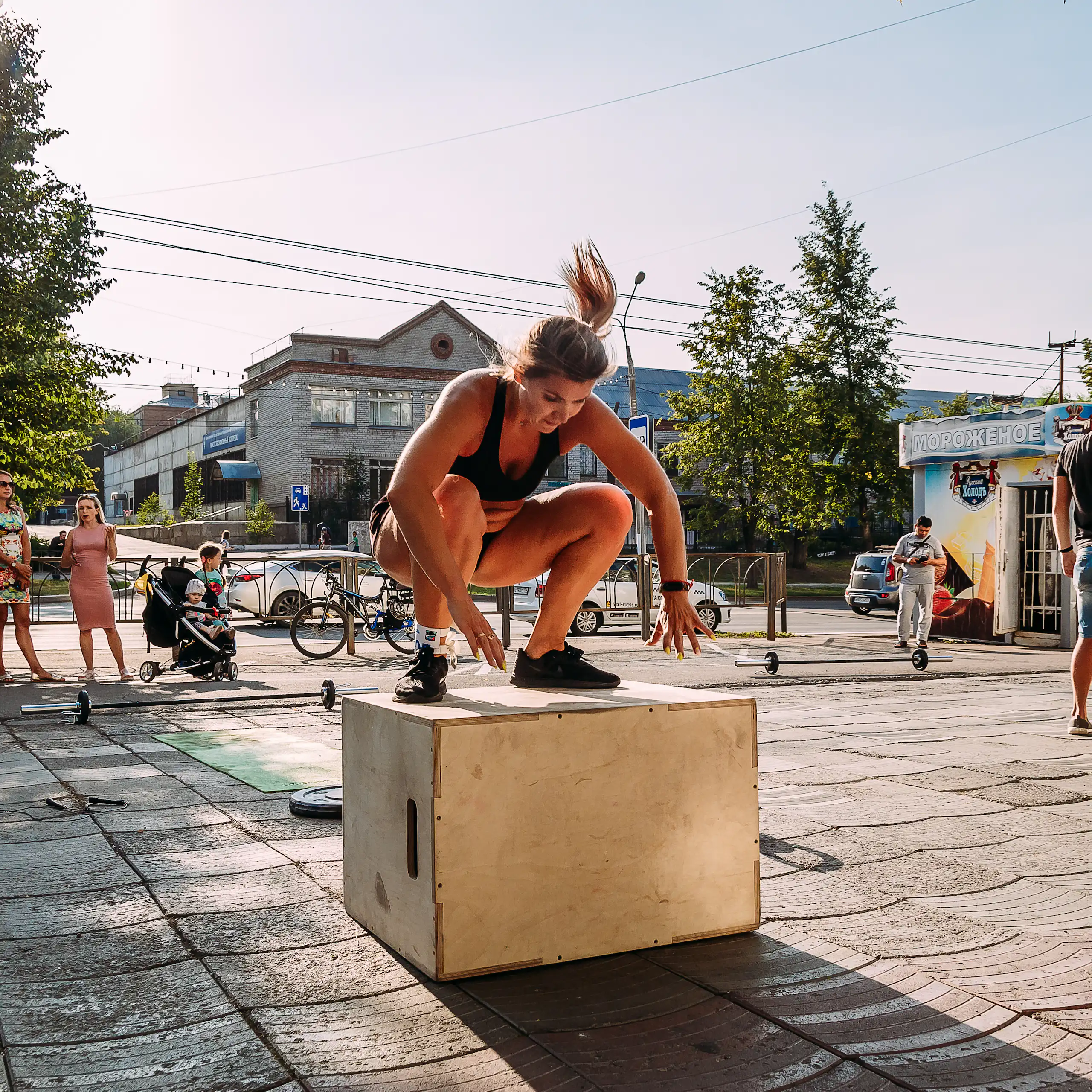 Una mujer salta sobre un cajón de madera.