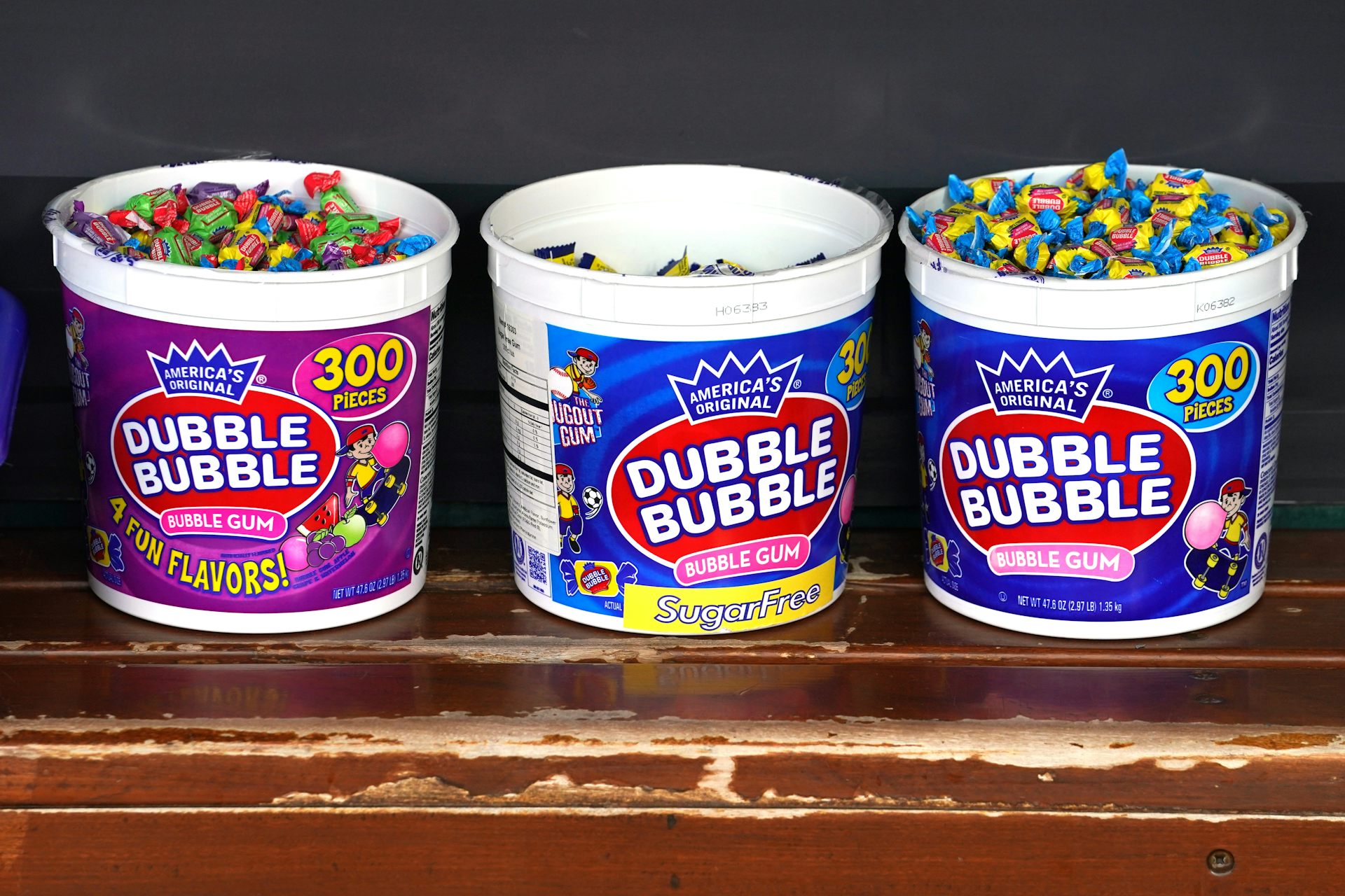 Three plastic tubs full of individually wrapped bubble gum