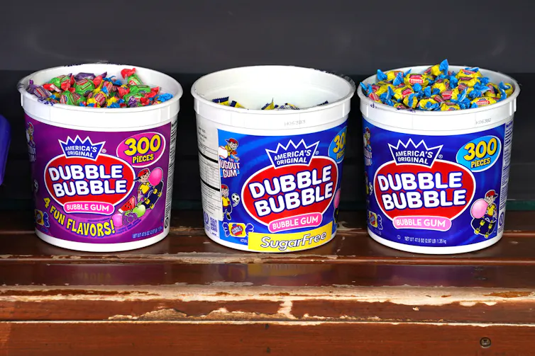 Three plastic tubs full of individually wrapped bubble gum